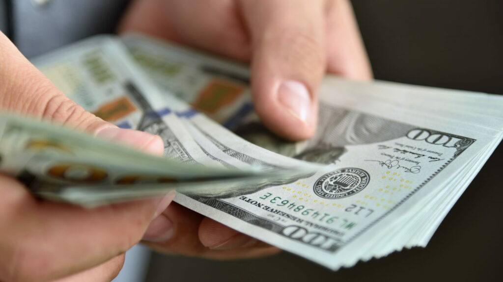 Hands holding U.S. $100 dollar bills